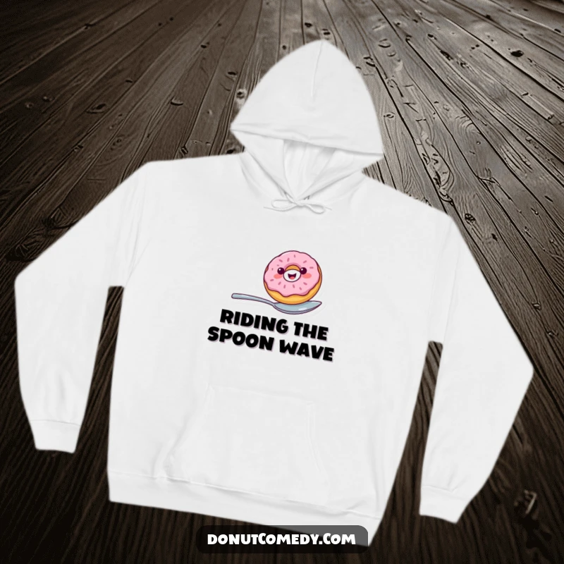 Funny hoodie with a cheerful donut character balancing precariously on a spoon, bringing humor and warmth together.